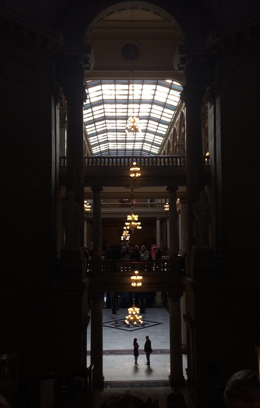 A man and woman are silhouetted at the bottom of the grand staircase at the Indiana State House.